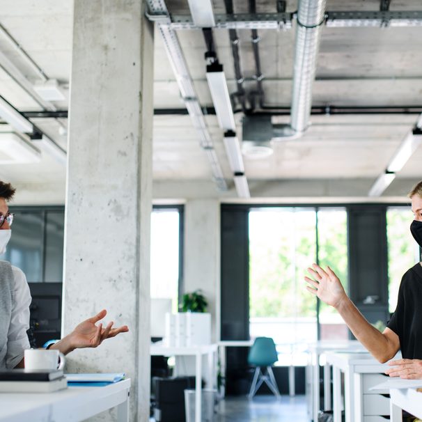 Young,People,With,Face,Masks,Back,At,Work,In,Office