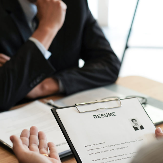 Examiner,Reading,A,Resume,During,Job,Interview,At,Office,Business